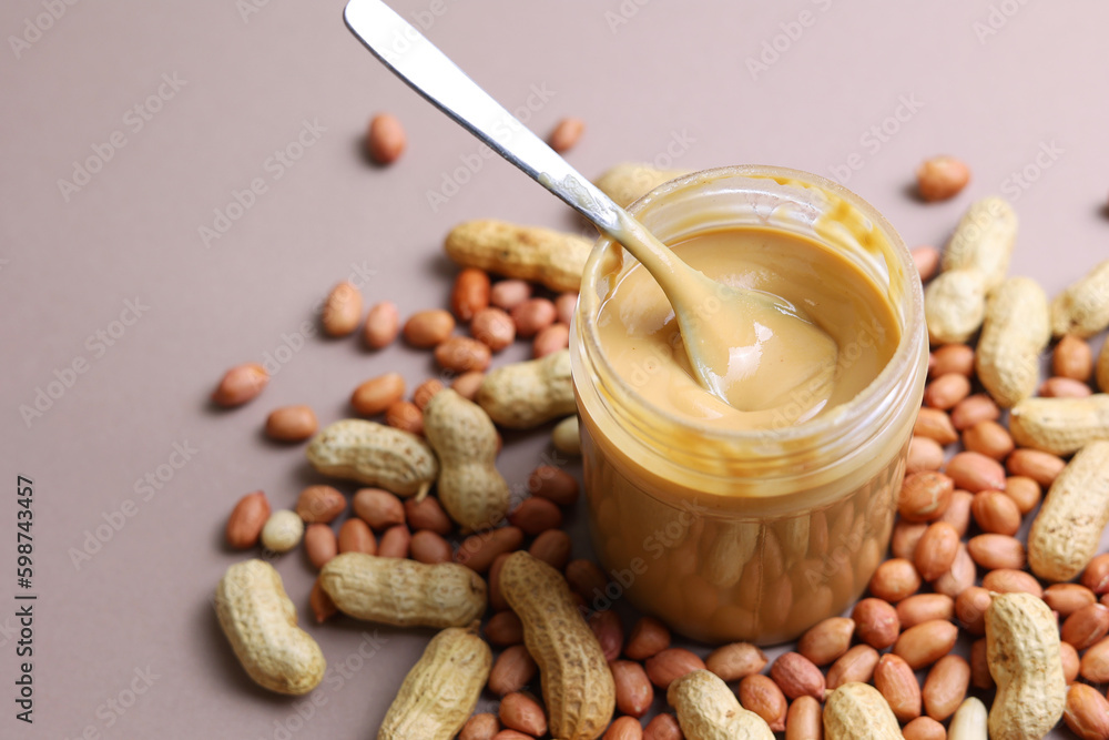 peanut butter and raw peanuts on a colored background peanut butter and raw peanuts on a colored background