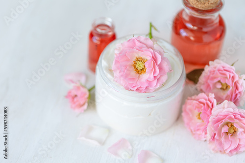 Premium skin care beauty treatment with pink rose petals. Plant-based pure organic ingredients in cosmetics. Jar of body or face moisturiser  lotion. Flower extract  natural youth anti-age elixir