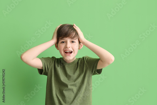 Surprised little boy on green background. Children's Day celebration