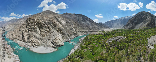 A 180-degree aerial panorama of a valley and a flowing river of green glacial water, located between the surrounding mountains.