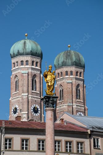 Münchner Frauenkirche mit Marienfigur im Vordergrund.
