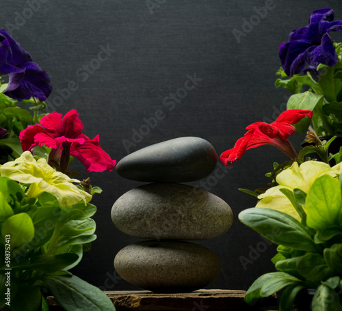 background podium for product presentation with zen stones .gray oval stones on a gray background with flowers