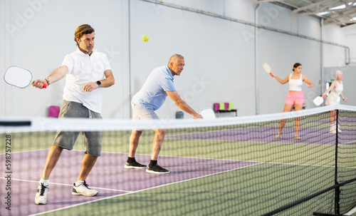 Athletic men playing pickleball tennis