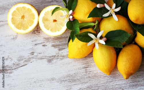 ripe lemons and flowers on table