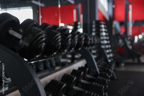 Many different dumbbells on stand in gym