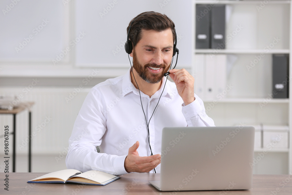 Hotline operator with headset working in office Hotline operator with headset working in office