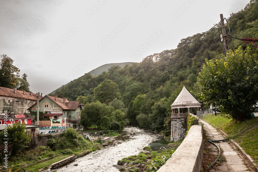 Panorama of the river Cerna in Baile Herculane, Romania, with individual houses and spa and thermal baths in the middle of the mountains in the romanian countryside. Panorama of the river Cerna in Baile Herculane, Romania, with individual houses and spa and thermal baths in the middle of the mountains in the romanian countryside.