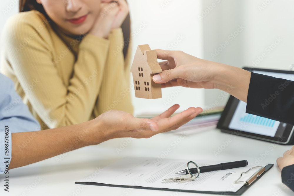 Realtor agent giving a home model to new owner after signed lease agreement. Realtor agent giving a home model to new owner after signed lease agreement.