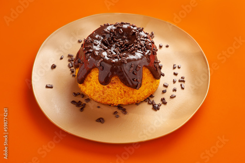 Mini volcano carrot cake with chocolate topping and chocolate sprinkles on orange background photo