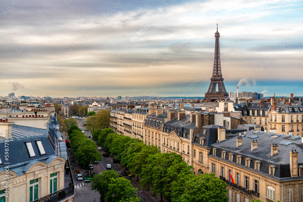 Eifel Tower against colorful sky and old town building in Paris, France. View from the roof top
