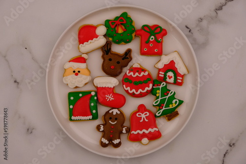 tasty Christmas cookies on a white ceramic plate. delicious colorful Christmas cookies. kue kering natal. Santa clause. Christmas tree. ginger cookies. 