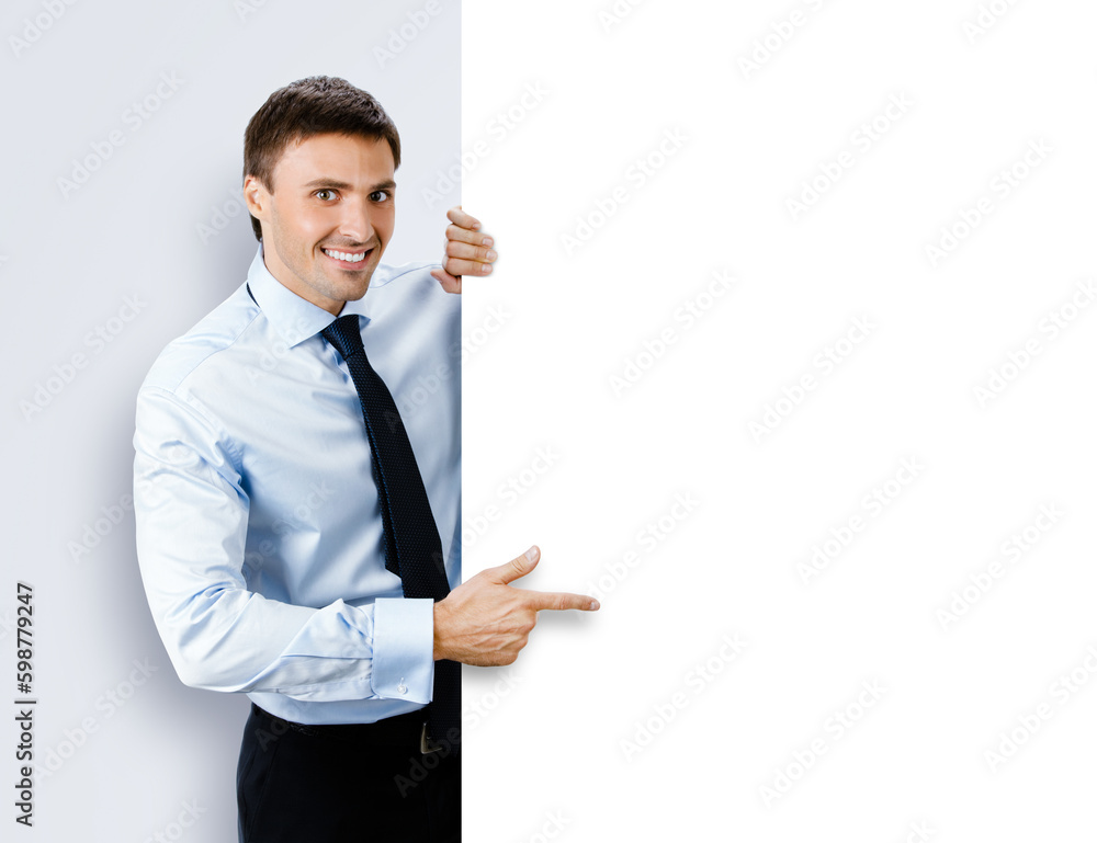 Image of business man, employee, professional in confident shirt wear. Businessman stand behind, hang over, show point finger empty white banner signboard. Isolated grey gray background Image of business man, employee, professional in confident shirt wear. Businessman stand behind, hang over, show point finger empty white banner signboard. Isolated grey gray background