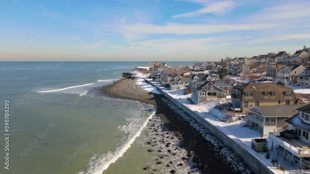 Aerial Forward motion flight parallel to Snowy Seawall. Coastal Homes with beachfront. Drone. Aerial Forward motion flight parallel to Snowy Seawall. Coastal Homes with beachfront. Drone.