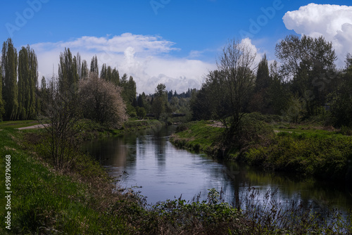 2023-04-29 THE SAMMAMSIH RIVER WITH FOLIAGE ALONG THE BANKS AND A NICE SKY NEXT TO THE BURK GILMAN TRAIL IN REDMOND WASHINGTON