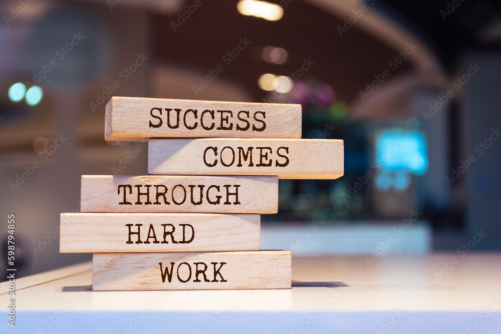 Wooden blocks with words 'Success comes through hard work'.