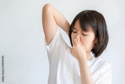 Woman covering her nose because of the smell of her sweat.