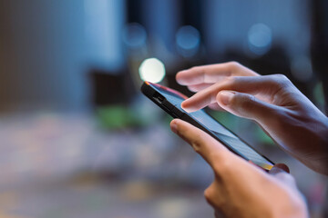Close-up male hand using smartphone at meeting room blur bokeh background. searching data networks or chatting online. typing sending message. mockup mobile phone wireless.
