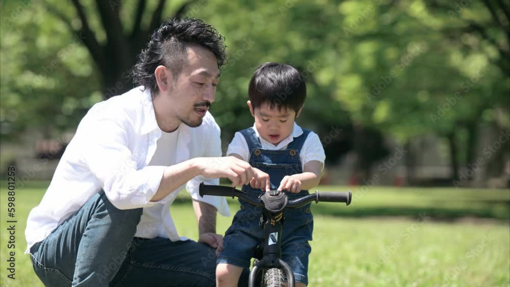 自転車の練習をする親子 新緑の公園でレジャー パパと男の子の動画 自転車の練習をする親子 新緑の公園でレジャー パパと男の子の動画