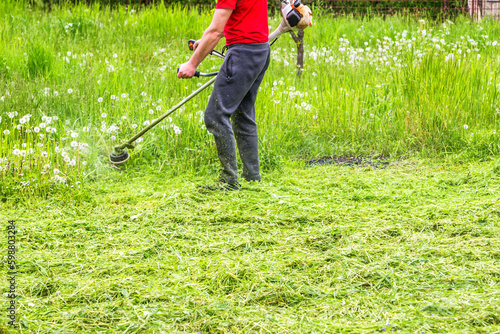 The gardener cutting grass by lawn mower. 