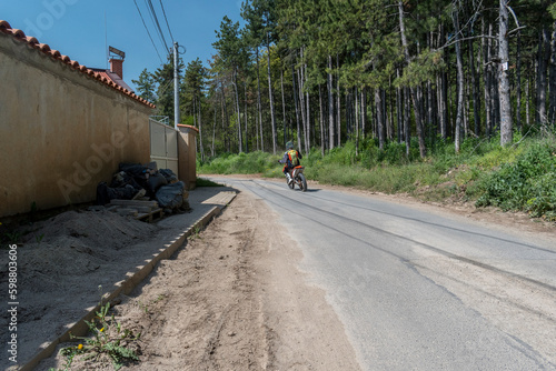 A person driving a motorcycle on an asphalt road.