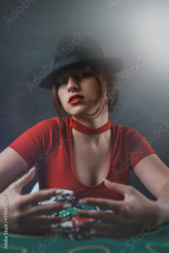 sexy woman with poker cards and chips at poker table in casino. the most gambling game