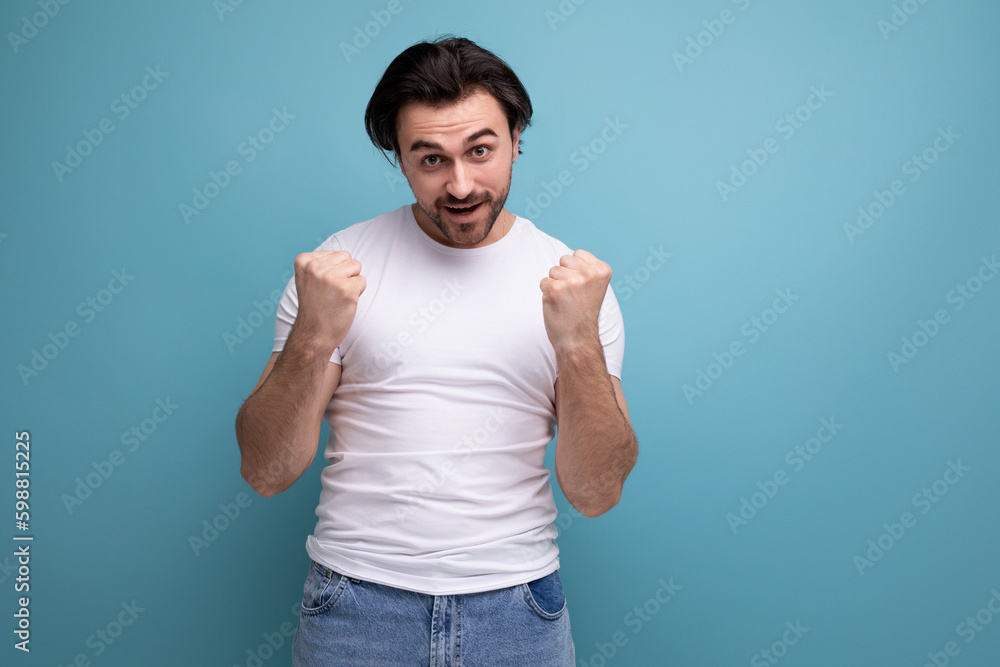 brutal young brunette guy in white t-shirt holding fists brutal young brunette guy in white t-shirt holding fists