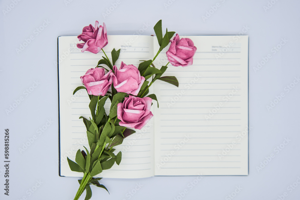 Fototapeta premium Roses and notebook on white background