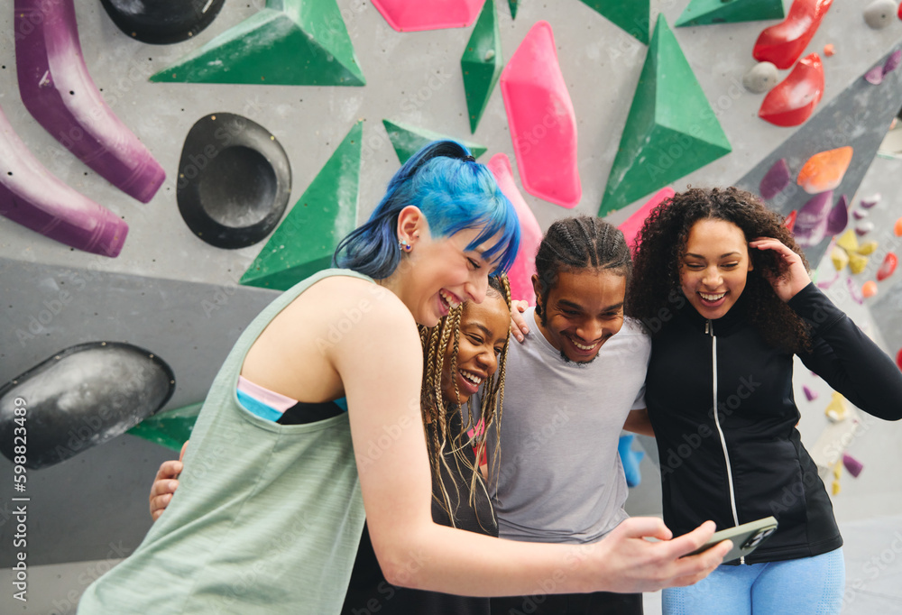 Fototapeta premium Group Of Multi-Cultural Friends Looking At For Selfie By Climbing Wall At Indoor Activity Centre