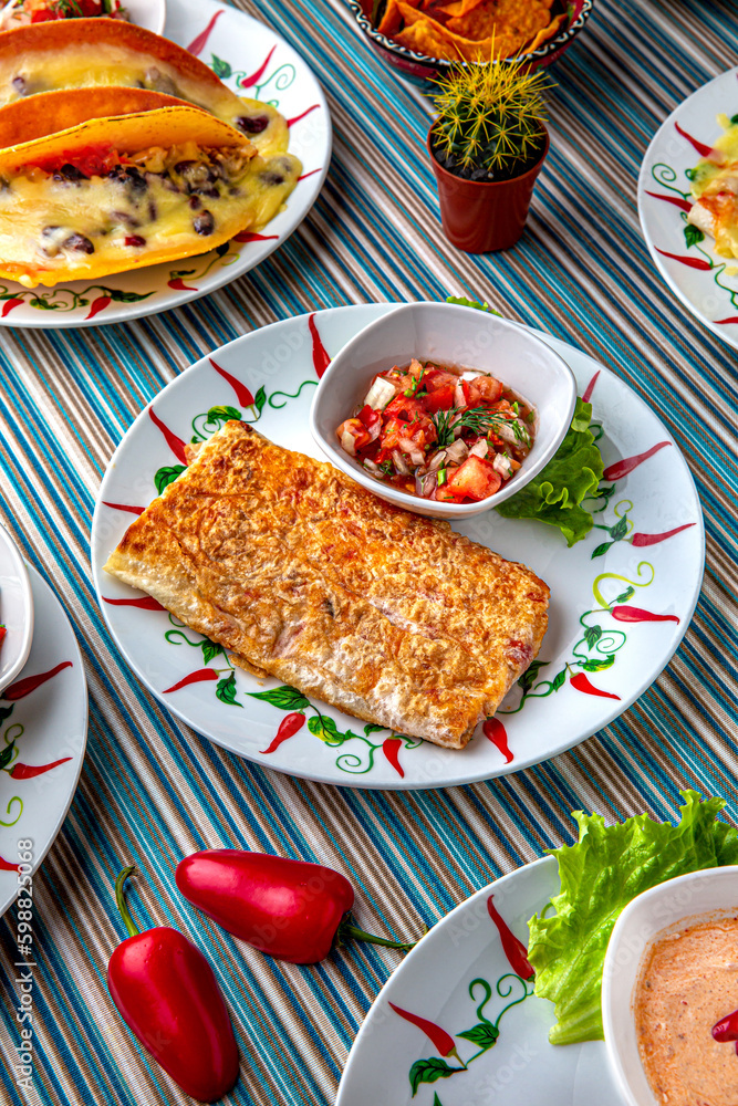 Traditional mexican food. Chimichanga with meat and vegetables. Colorful Food Table Celebration Delicious Party Meal Concept. Traditional mexican food. Chimichanga with meat and vegetables. Colorful Food Table Celebration Delicious Party Meal Concept.