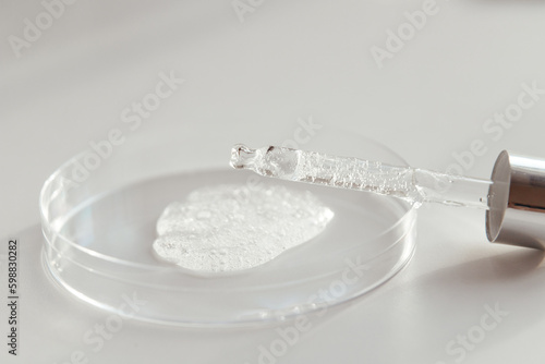 Pipette with Sample of Gels Cosmetic Product in Petri Dish on white background photo