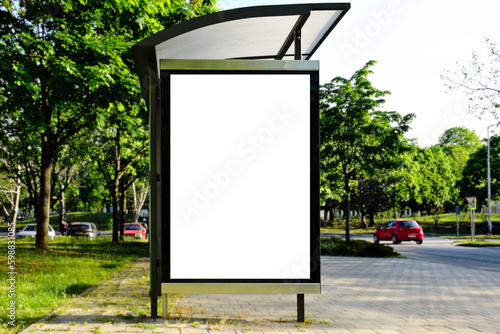 bus shelter blank with ad panel. billboard display. empty white lightbox sign at bus stop. glass structure. city transit station. urban street. green park setting. outdoor bus shelter advertising