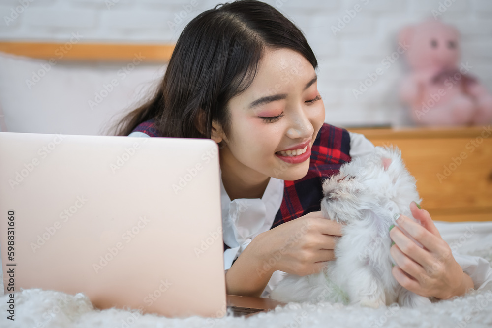 The white dog looks content and relaxed enjoying the company of its owner while laptop place beside her. The white dog looks content and relaxed enjoying the company of its owner while laptop place beside her.