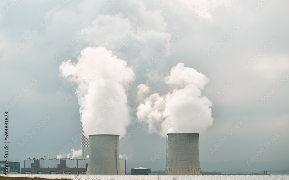Twin nuclear power stacks rise above. A power plant in Europe. Twin nuclear power stacks rise above. A power plant in Europe.