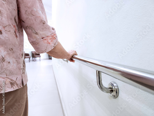 hand of senior woman holding aluminum handrails in hospital.