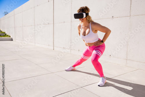 Fitness woman wearing virtual reality glasses and working out outdoors
