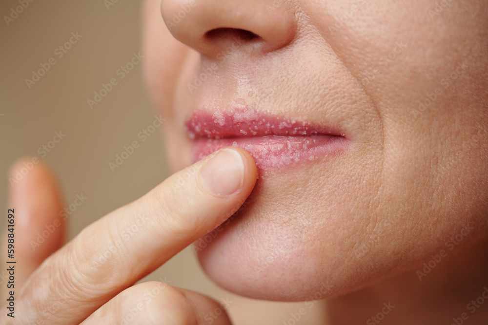 Obraz premium Closeup image of woman scrubbing lips to get rid of dead skin cells