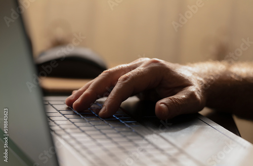 Closeup of hands using laptop at home