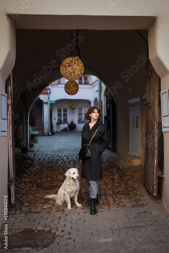 Cute funny girl portrait with her golden dog on street 
