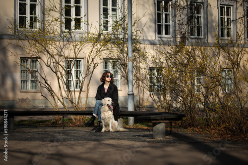 Obraz na płótnie Cute funny girl portrait with her golden dog on street w salonie