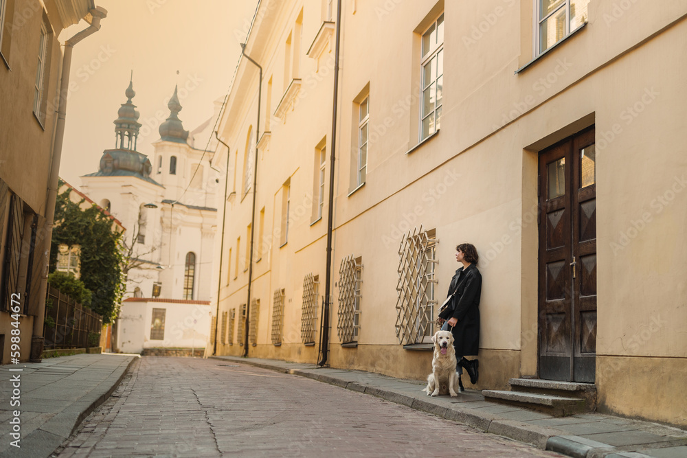 Cute funny girl portrait with her golden dog on street 