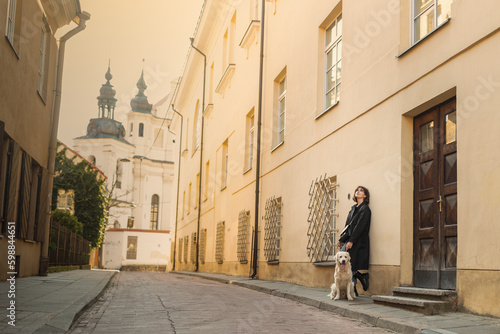 Obraz na płótnie Cute funny girl portrait with her golden dog on street w salonie
