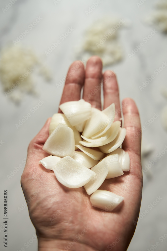 Chunk sliced onions on mans hand. Photo show how does onion sliced into quarters or chunks look like Chunk sliced onions on mans hand. Photo show how does onion sliced into quarters or chunks look like