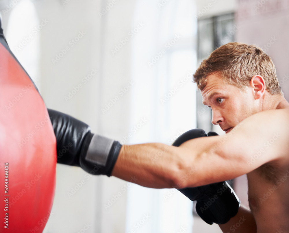 Strength and focus. A young boxer practicing with a punching ball. Strength and focus. A young boxer practicing with a punching ball.