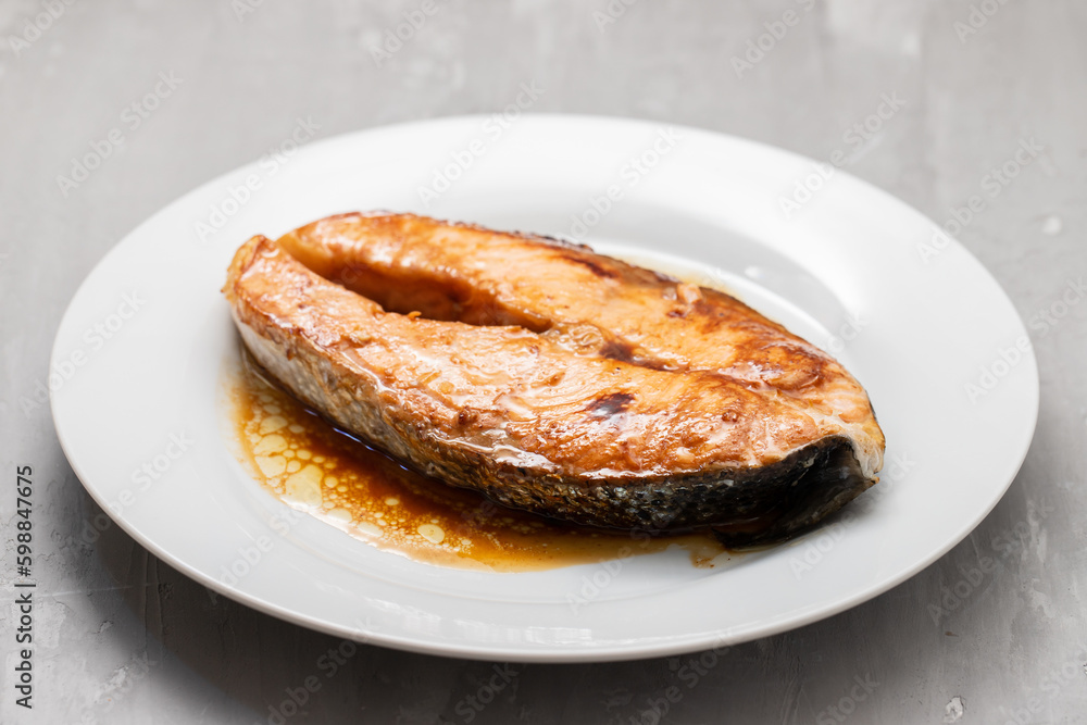 Fried salmon steak with sauce on white dish Fried salmon steak with sauce on white dish
