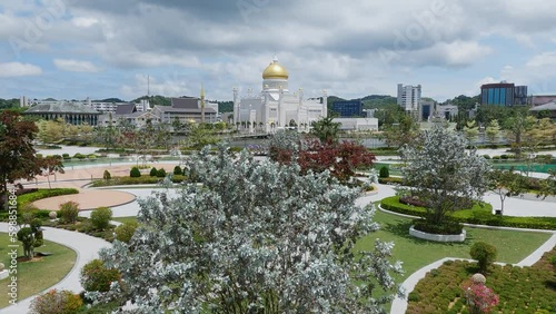 Masjid Sultan Omar Ali Saifuddin Mosque in Bandar Seri Begawan, Brunei Darussalam, spring shot with tree blooms in park photo