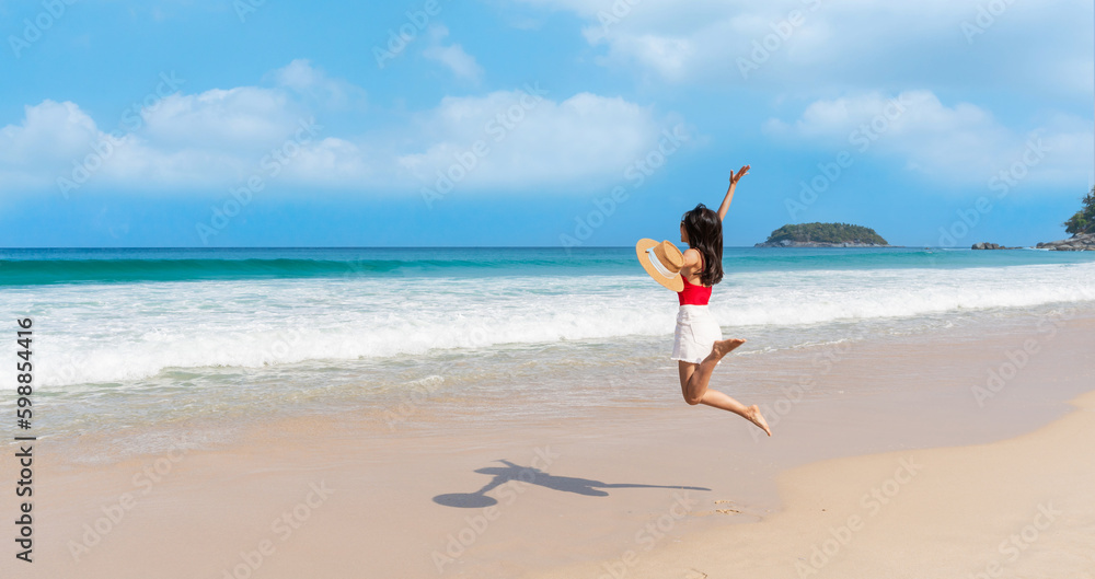 Happy young Asian female relax smile around beautiful tropical sea beach ocean with white cloud on blue sky in travel vacation. Summer and holiday concept. Free space Happy young Asian female relax smile around beautiful tropical sea beach ocean with white cloud on blue sky in travel vacation. Summer and holiday concept. Free space