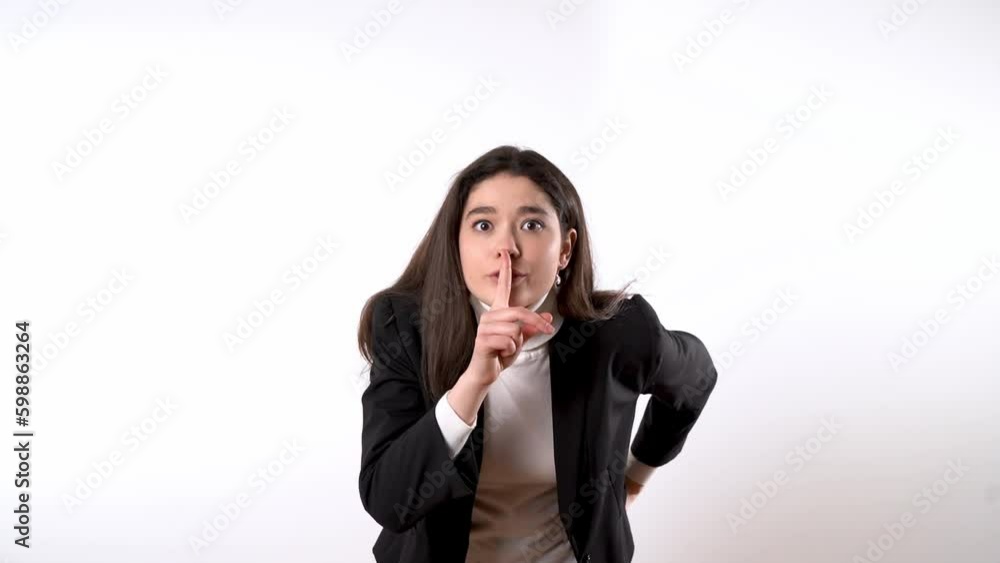 Smartly dressed young woman against white background drawing her forefinger to the mouth while making a silencing gesture to everyone around her Generative AI Smartly dressed young woman against white background drawing her forefinger to the mouth while making a silencing gesture to everyone around her Generative AI