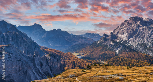 Stunning alpine Landscape at sautumn sunny day. Alpine meadow and road, mountains on background. amazing nature Landscape. Dolomites Alps. Italy. photo