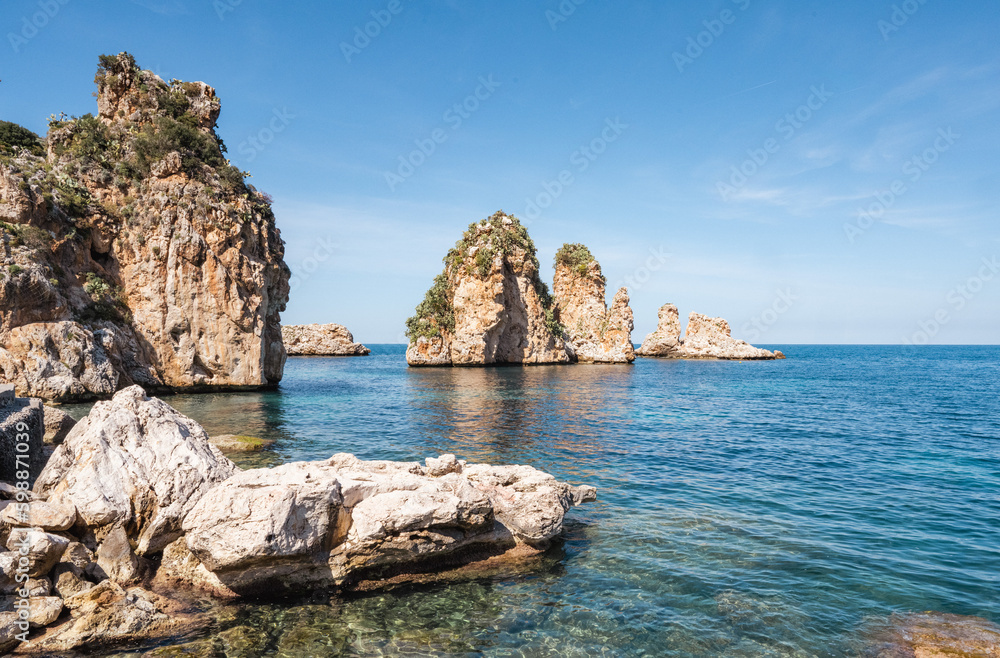 The bay of the former tuna catchers Tonnara di Scopello is located on the blue Tyrrhenian Mediterranean Sea in a picturesque setting between rugged rocks and green hills.