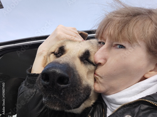 An adult girl and a dog in a car. The journey of a woman and an animal. Friendship of a shepherd pet and a mature lady photo